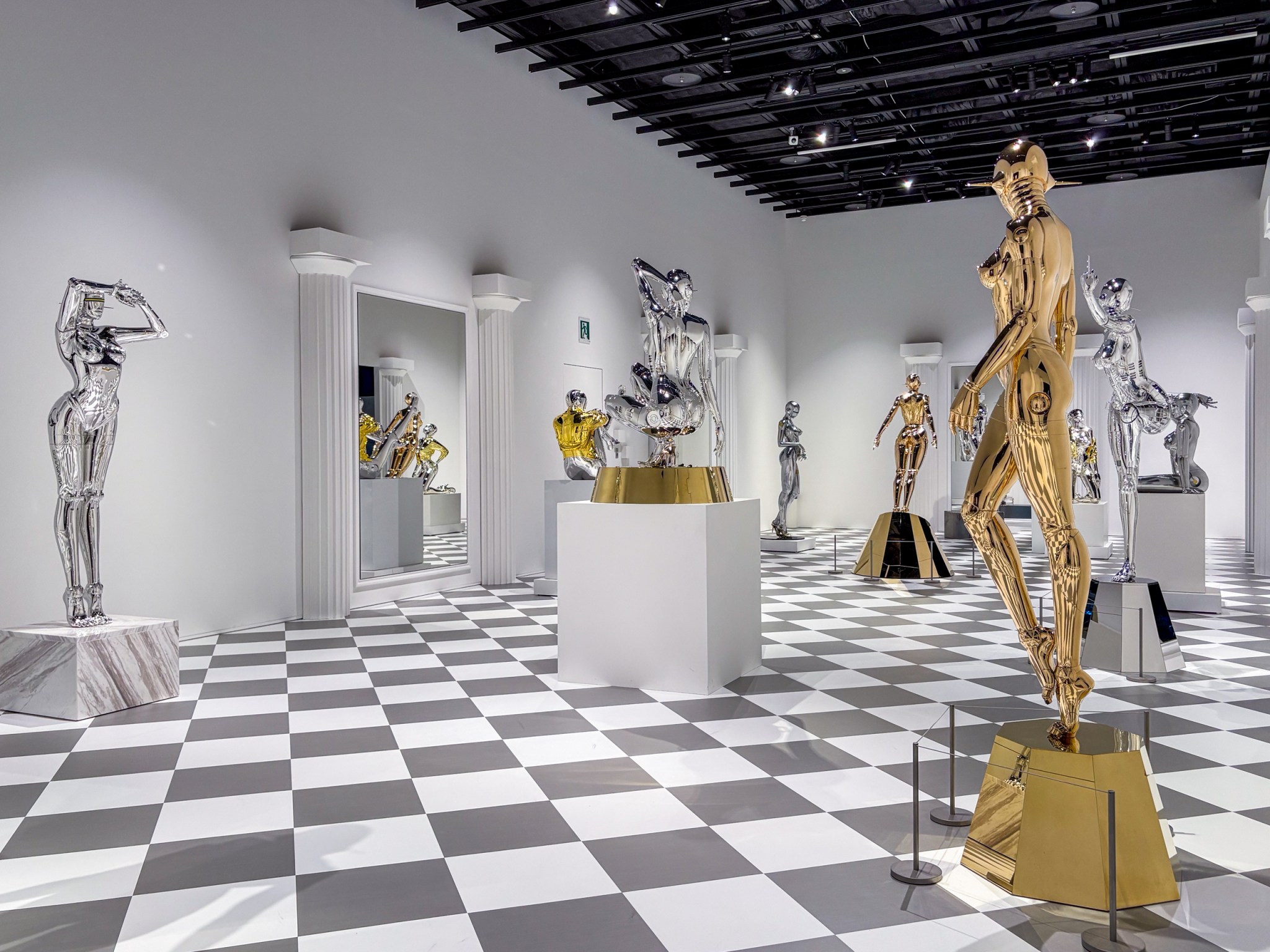 现代艺术展览,展示多个金属雕塑,室内光线明亮,地板为黑白格子图案。